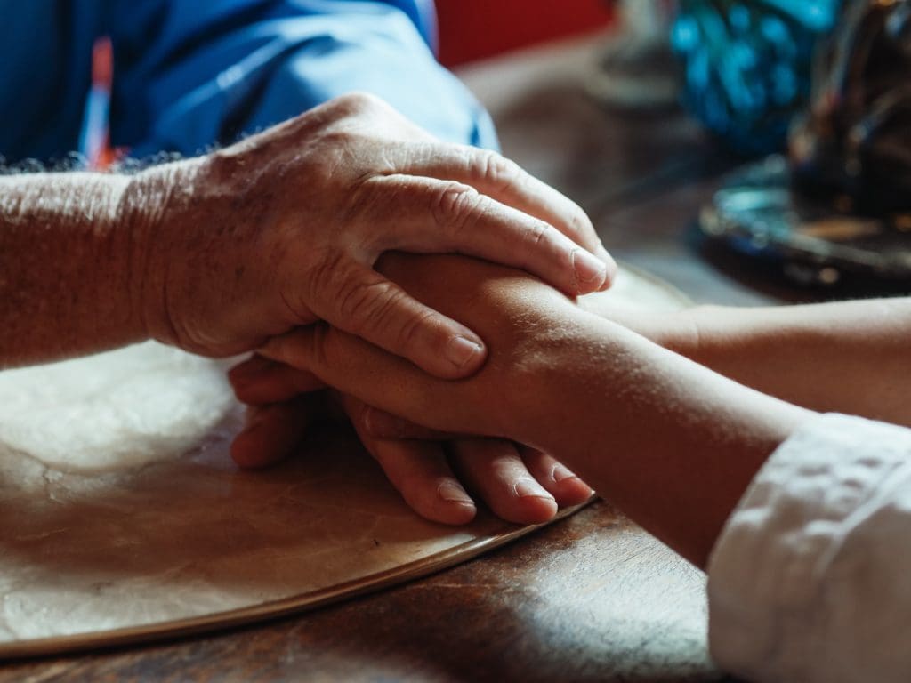 Male hands embracing female hands in a comforting way